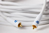 White audio cable with gold connectors on a blurred background