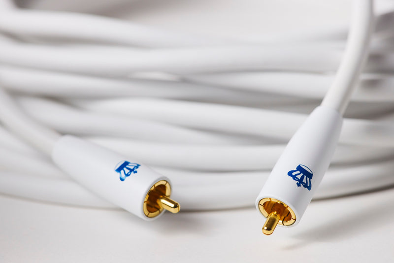 White audio cable with gold connectors on a blurred background