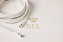 White audio cable with gold connectors on a light grey background, featuring the REL Acoustics Ltd logo.